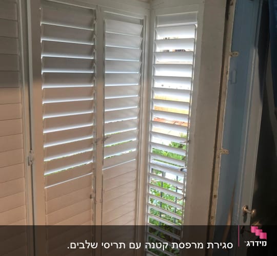 תריסי אלומיניום לבנים בחלון פינת חדר